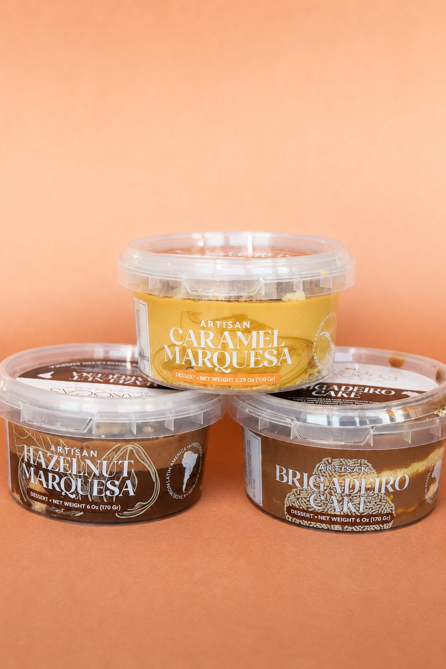 Three artisan dessert cups stacked in a pyramid against a terracotta backdrop